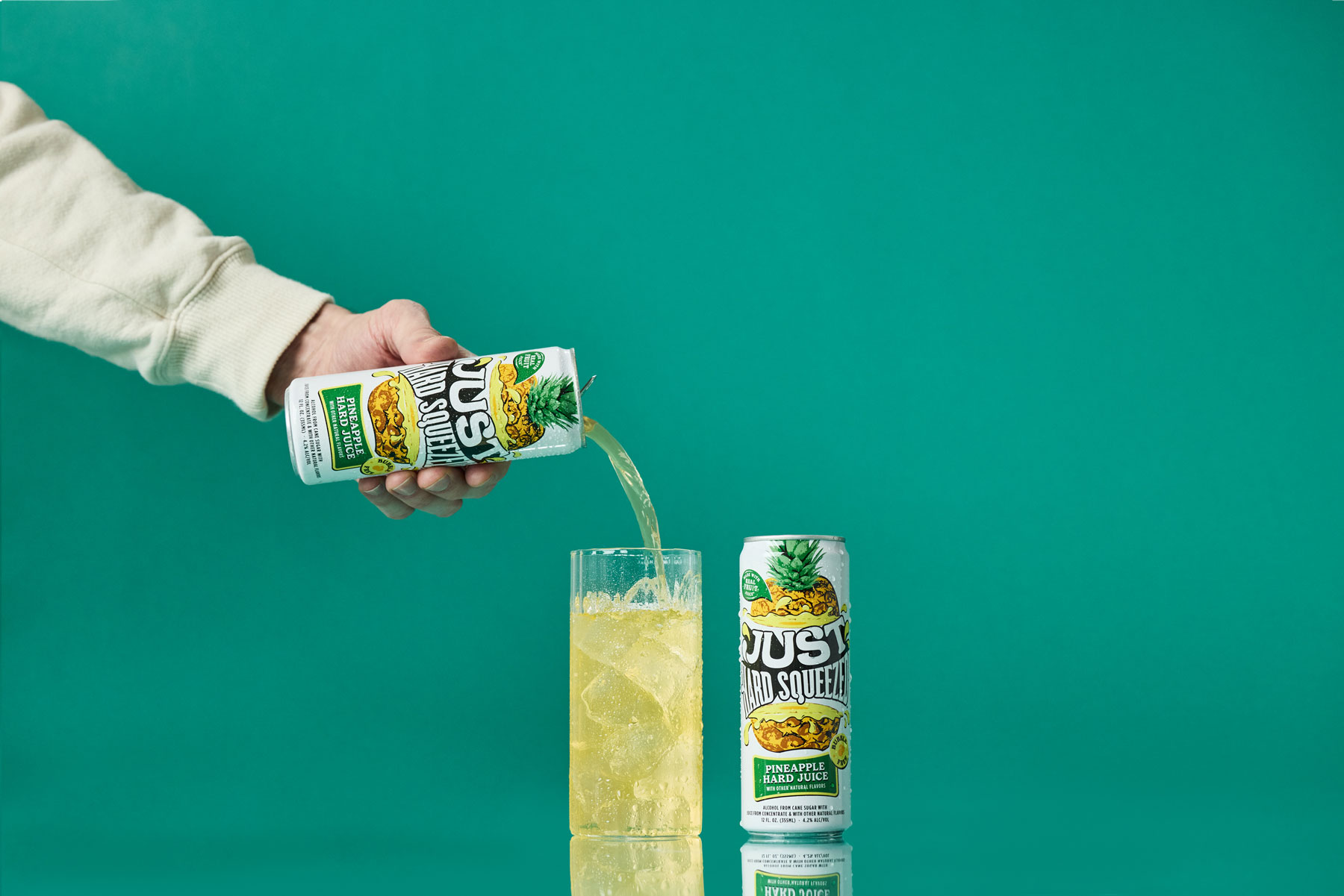 a can of just hard squeezed pineapple next to a glass being poured into