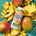 can of just hard squeezed mango laying on a bed of fresh mangos