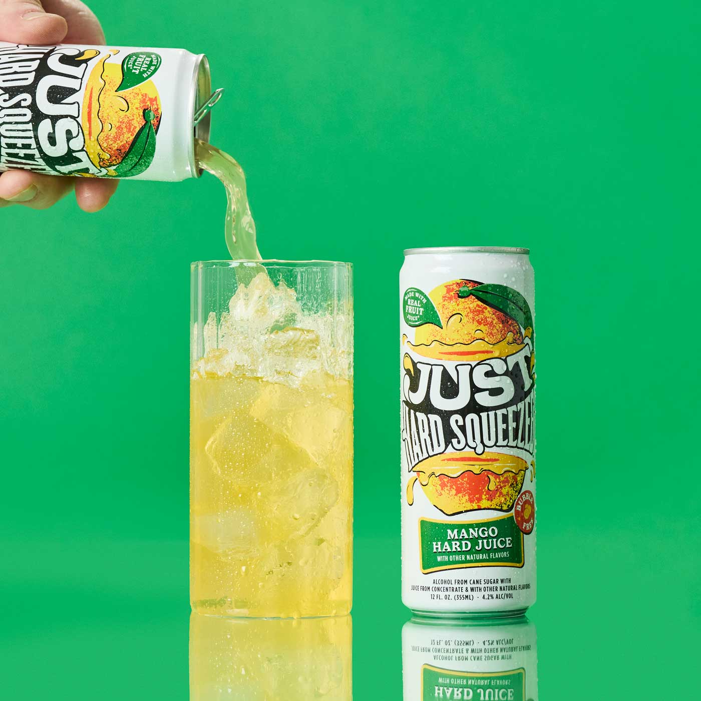 a can of just hard squeezed mango next to a glass being poured into