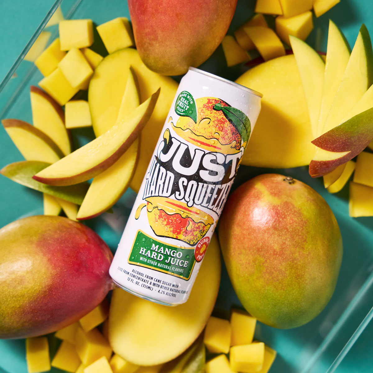 can of just hard squeezed mango laying on a bed of fresh mangos