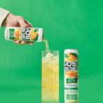 a can of just hard squeezed mango next to a glass being poured into