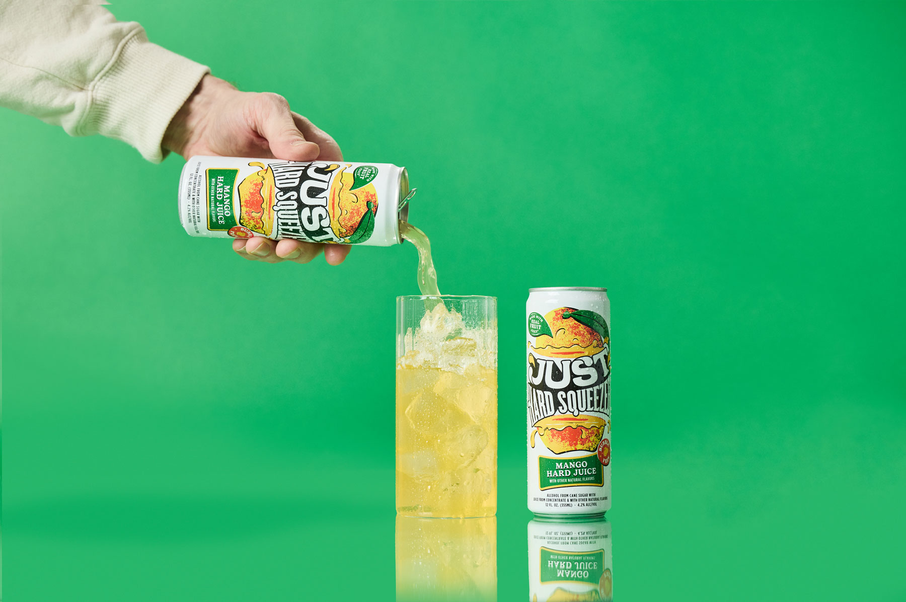 a can of just hard squeezed mango next to a glass being poured into