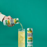 a can of just hard squeezed pineapple next to a glass being poured into